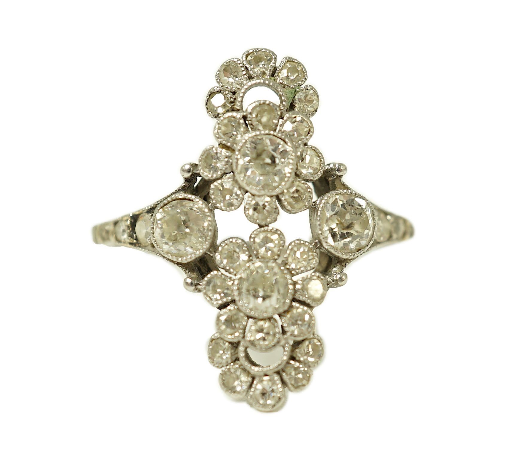 A 1920's platinum and millegrain diamond set flower head cluster upfinger ring